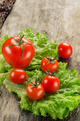 tomatoes and salad on aged wooden board