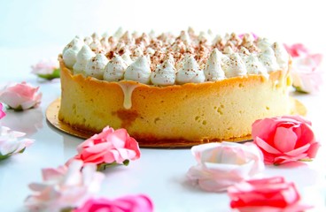 Delicious cake with custard inside and cream with cacao on top. Decorated with tender roses buds.