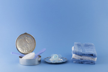 Baby boy luxurious items collection isolated on pale blue background. Hairbrush and comb in a...