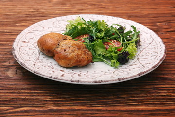 Smoked chicken leg with salad on wooden table