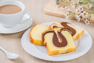 Butter cake sliced on plate and cup of coffee