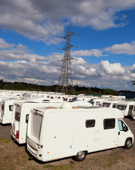 Caravans stored in rows on a cloudy day with blue sky day. With space for text. 