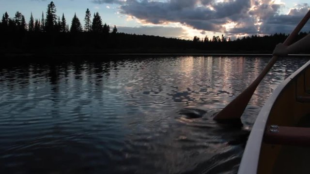 Une personne pagaie un canoe dans la nuit