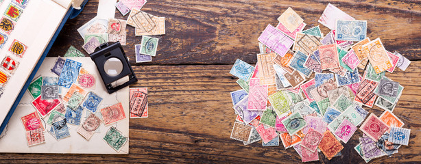 Old postage stamps and magnifying glass - Powered by Adobe
