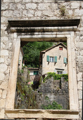 Fototapeta na wymiar View through an old window in the city of Kotor, Montenegro. Remains of a house built by the Romans in the Middle Ages.