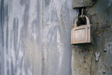 Detail of the painted metal door with old padlock, closeup