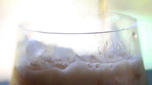 Soft drink poured into a glass creates many bubbles