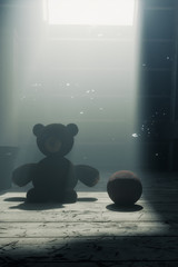 Teddybär und Lederball auf dem Dachboden in Lichtstrahlen