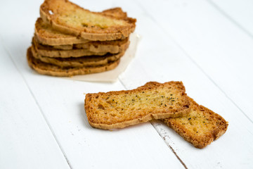 Stack of crostini on white background. A crostino is a small slice of toasted or grilled bread in Italian cuisine (appetizers). A versatile snack to eat plain, with vegetable, cheeses & meats!