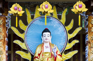Standing Amitabha Buddha statue on the entrance to Quang Minh Mahayana Buddhism temple in Da Nang, Vietnam 