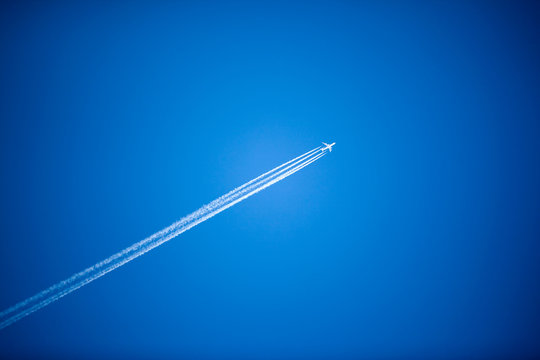 Fototapeta White plane flying high in the sky