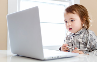 Little toddler girl using her laptop