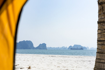 View from inside the tent located on palm tree beach in Ha Long (Halong) bay in Quang Ninh Province, Vietnam. Southeast Asia UNESCO World Heritage Site