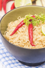 Instant noodles in bowl on wood background
