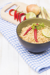 Instant noodles in bowl on wood background