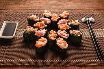 Appetizing japanese sushi. Set of tasty rolls served on brown straw mat, close up. Restaurant menu photo, traditional healthy seafood, food art.