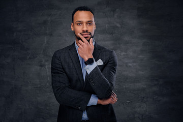 A stylish black male dressed in a suit over grey background.