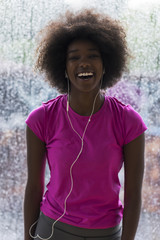 portrait of young afro american woman in gym while listening music