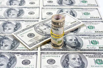 Fototapeta premium A stack of banknotes on a background of dollars 