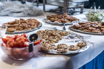Stack of mini Pizza on plates at the buffet during business meeting