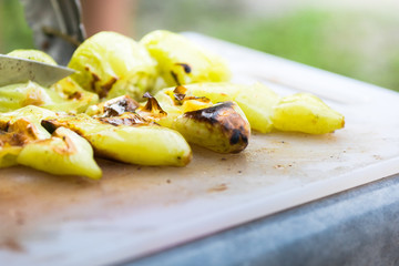 grilled green pepper cut on plastic cutting board, barbecue party