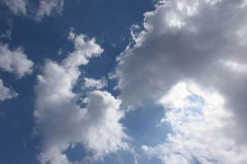 Fototapeta na wymiar 幻想風景・青空と雲に隠れた太陽「空想・対峙する雲のモンスターたち（右側のモンスターから、奥のモンスターたちを見る構図）」