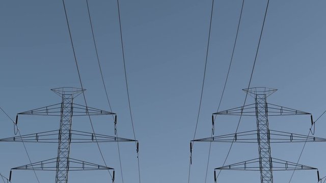 Electricity pylons. Moving along two row of pylons. electric high voltage pylon against clear blue sky. energy efficiency conception. loopable animation