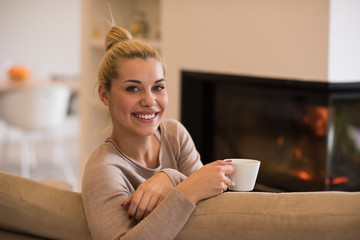 woman with a mug near a fireplace