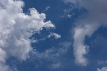Fototapeta na wymiar 下に伸びる不思議な雲（右）と青空「空想・雲のモンスターたち（左側など）変革、目指す、常識を覆す、可能性、不思議、成長企業などのイメージ