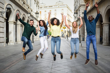 Group of friends jumping together outdoors