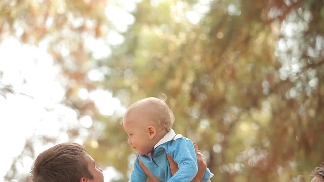 father lifts his son up in his arms