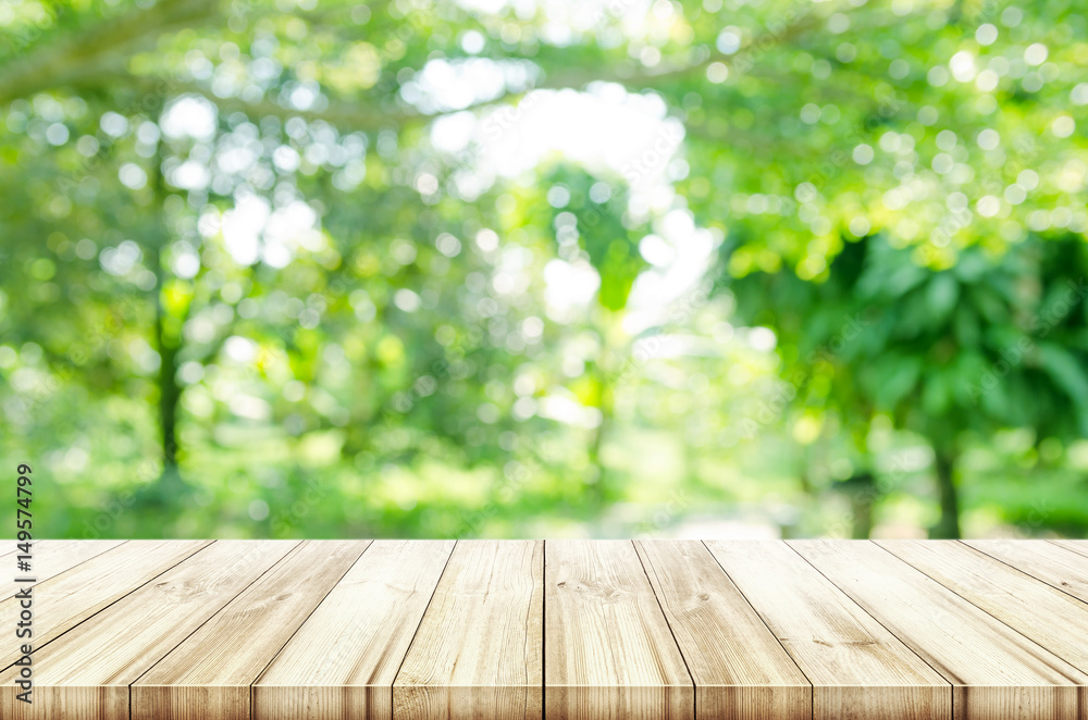 Wall mural empty wooden table top with blurred green natural background.