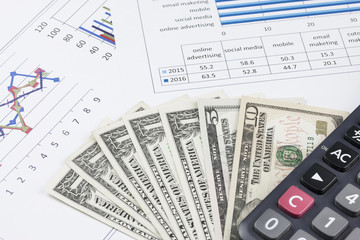 business concept : graph with calculator and money on stock market report as background