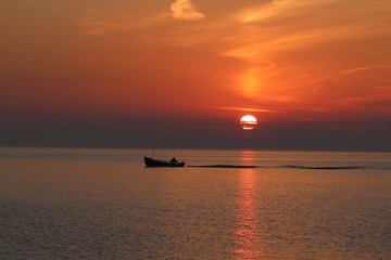 Fototapeta premium Angelboot bei malerischem Sonnenaufgang auf der Ostsee