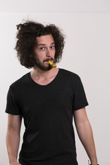 Portrait of a man in party hat blowing in whistle