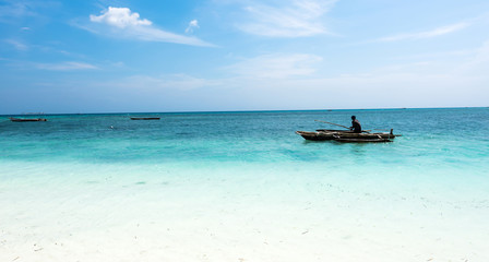 Fototapeta na wymiar landscape with man in a boat in ocean near African shore