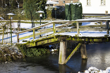 Fototapeta na wymiar Old wooden bridge over the moat Winter