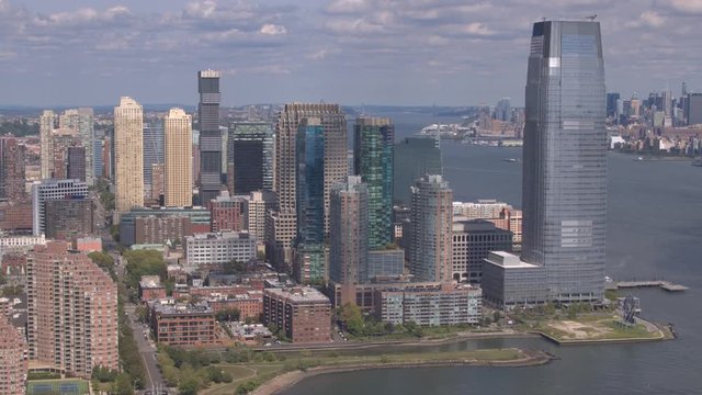 AERIAL: Flying around New Jersey downtown skyscrapers overlooking Lower Manhattan financial district in New York across the Hudson River. Helicopter flight around the high glassy downtown skyscrapers