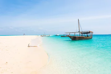 Aluminium Prints Zanzibar anchored boat on african seashore with blue sky on the background
