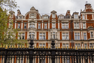 Sculpture of a London park with two red buses background