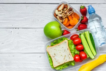 Zelfklevend Fotobehang schoollunchboxen met sandwich en verse groenten, fles water, noten en fruit © samael334
