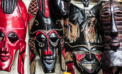 different colorful tribal wooden masks at african souvenir market
