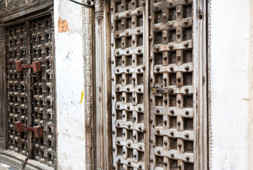 old massive wooden door with carving on the Srone Town street in Zanzibar