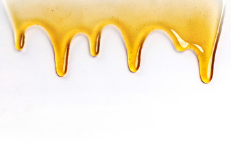 Dripping honey seamlessly repeatable from the top over white with copyspace and text