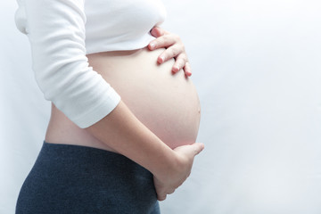 Close Up Of Pregnant Woman Holding Tummy