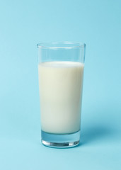 Fresh glass of milk on blue background