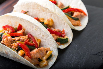 Mexican tacos with pork and vegetables. Al pastor taco on slate tableware...
