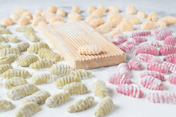 Homemade raw gnocchi with spinach, carrots and beets on the table with the Board