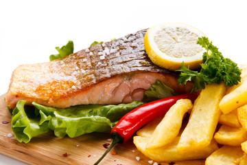 Grilled salmon with french fries on cutting board