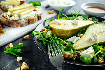 Fresh sweet Pears salad and bruschetta with cottage cheese, walnut on white board.